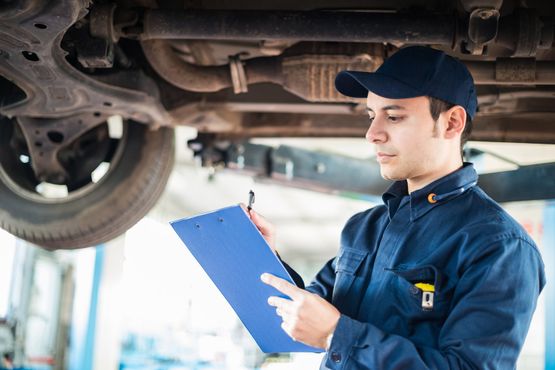 A mechanic filling checking what needs replacing on the car he is working on